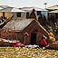 Iles Uros -  un village plus important et plus habit. Les indiens habotent dans les maisons plus rcentes  l'arrire plan. Devant les tals d'artisanat.